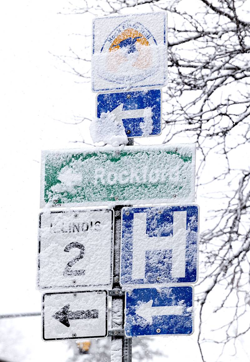 Wet, heavy snow sticks to signs and trees as the Sauk Valley gets its first snow of the winter Tuesday, Jan. 9, 2024.