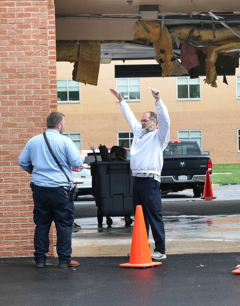 Northwestern Medicine Valley West Hospital employees discuss the damage in the ambulance bay after a truck too tall for the clearance tried to drive through it Tuesday, May 7, 2024, at the hospital in Sandwich. There was visible damage to the ceiling of the bay with insulation and wall material hanging down.