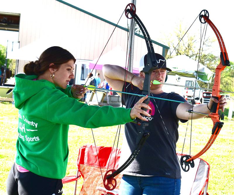 Hailey (left), 14 and Allison,16, draw back the bow for an archery demonstration Saturday, May 10, 2025, at P&C Little Rascals’ open house.