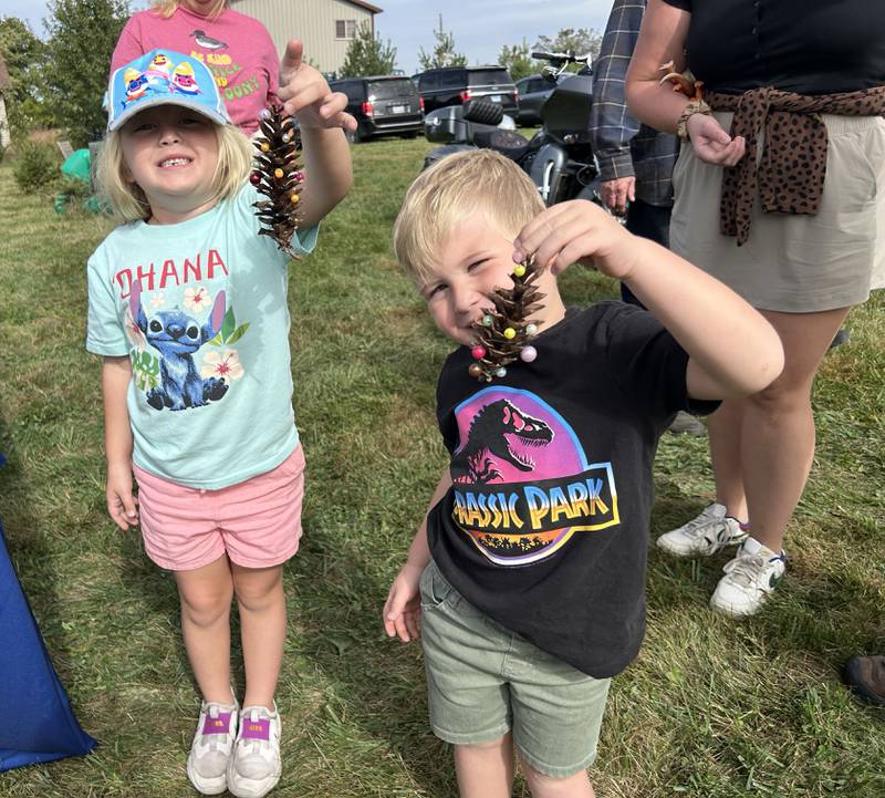 George and Olivia Creamean, ages 4 and 6, turned a pine cone into a Christmas ornament with the help of Illinois Extension Master Gardeners Sara Pohl and Leslie Ciaccio when they visited Ponto Ranch during the Ogle County Farm Stroll with their family on Sunday, Oct. 12, 2025.