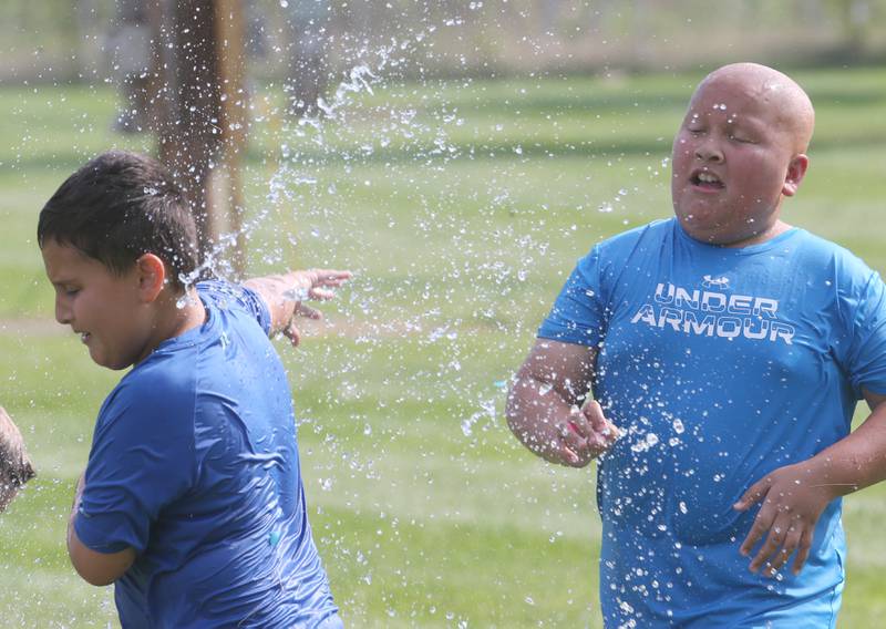 Ian Piecha of Cedar Point, gets hit in the face by a water balloon by Ashton Funentes of Cedar Point, during National Night Out on Tuesday, Aug. 5, 2025 in Oglesby. Oglebsy Police, Fire and EMS along with Utica Fire, Illinois State Police and OSF Lifeflight helicopter also attended. The event featured food, foam machine, bounce house, games and more. National Night Out is an annual community policing campaign held on the first Tuesday of August to create police-community partnerships and build safer neighborhoods