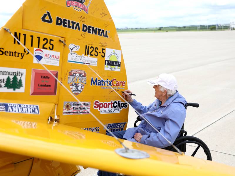 Helen Ehlers, 99, of Wheaton signs her name on the tail after a Dream Flight at the DuPage Airport in West Chicago on Saturday, July 29, 2023. The plane is a 1942 open cockpit Boeing Stearman, the same airplane used to train military aviators in the 1940s. The flights were courtesy of Ageless Aviation Dreams Foundation, a non-profit organization to honor U.S. military veterans living in long-term care facilities. Ehlers is a United States Marine Corps veteran.