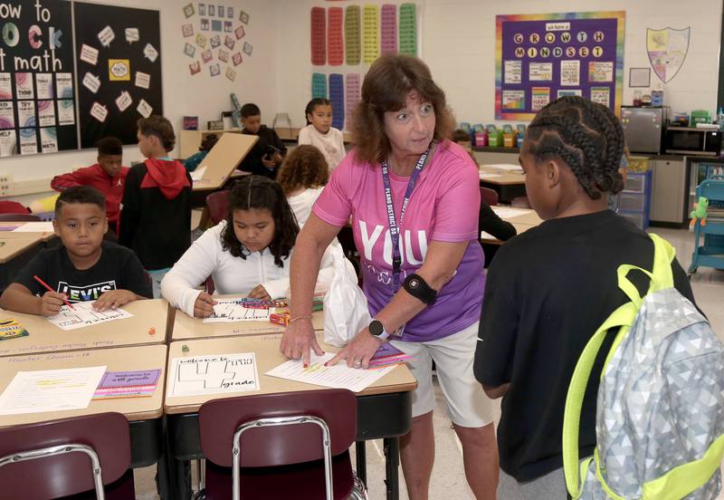 Fourth grade teacher Fran Kenyon helps students settle in on the first day of school at Emily G. Johns School in Plano on Thursday, Aug. 17, 2023.