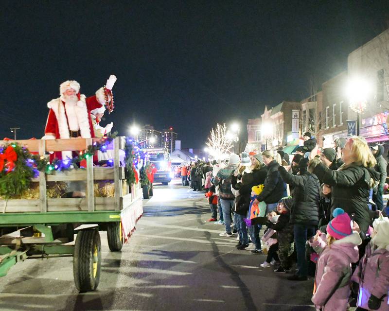 Santa and Mrs. Clause wave to community members on the parade route on Friday Nov. 24, 2023, held in downtown Wheaton.