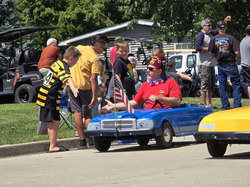 The Red Fez Shrine Club of Pontiac gives out high fives to children parade goers Sunday, Aug. 11, 2024, during the Wenona Days Grand Parade.