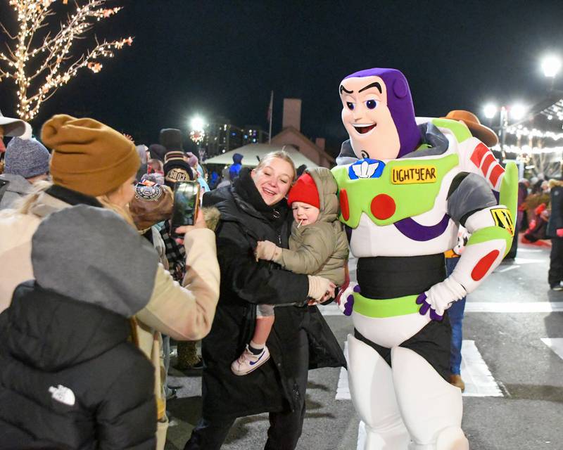 Jessica Litavsky of Glen Ellen gets a photo of her sister Diana Panek and nephew Jackson Panek, 2 years old, with Buzz Light Year from Toy story during the holiday parade in downtown Wheaton on Friday Nov. 24, 2023.