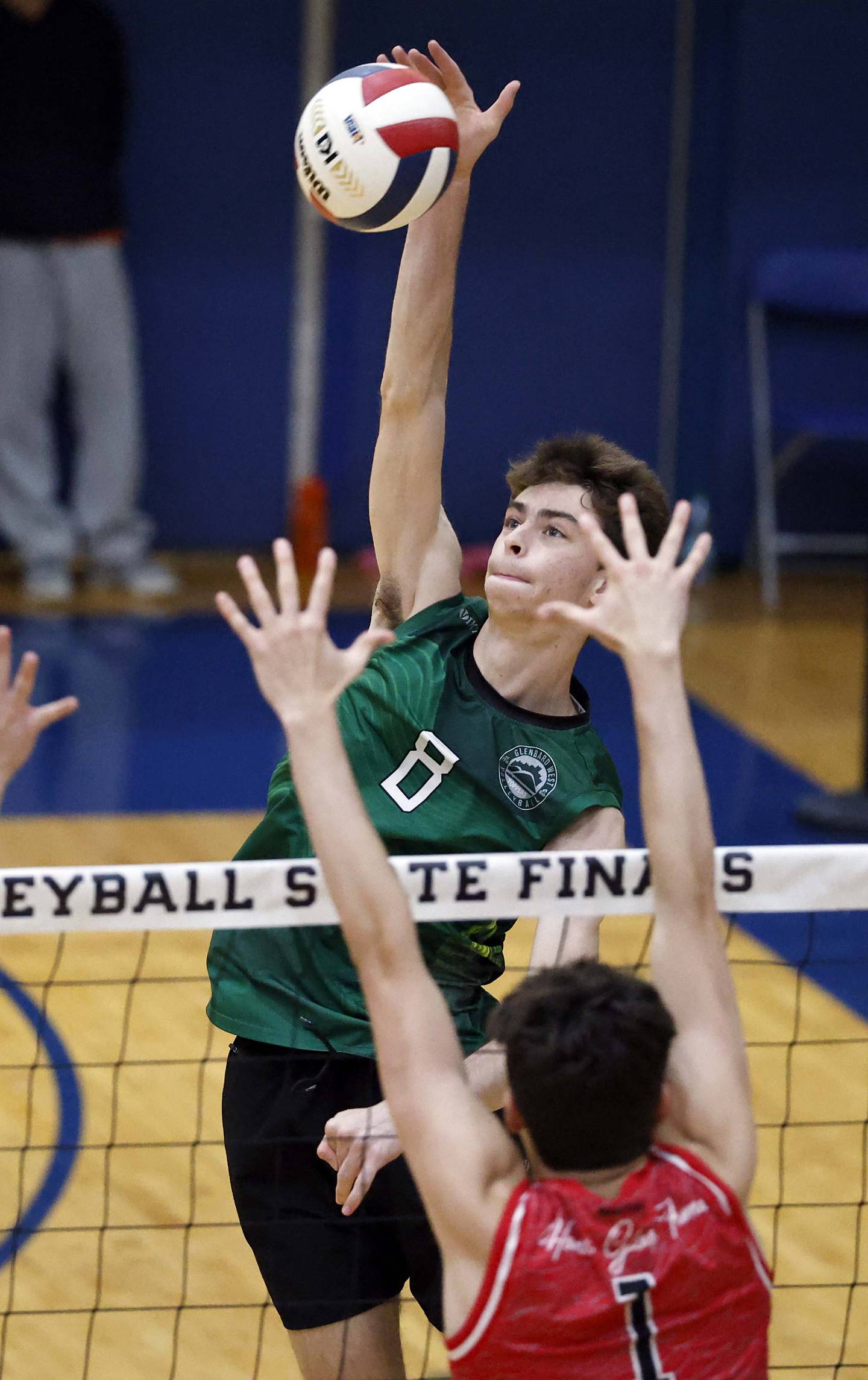 Glenbard West's Charlie Clifford (8) moves the ball past Marist's Matt Rahn (1) during the championship match of the IHSA State Final Boys Volleyball Tournament Saturday, June 7, 2025 in Hoffman Estates.