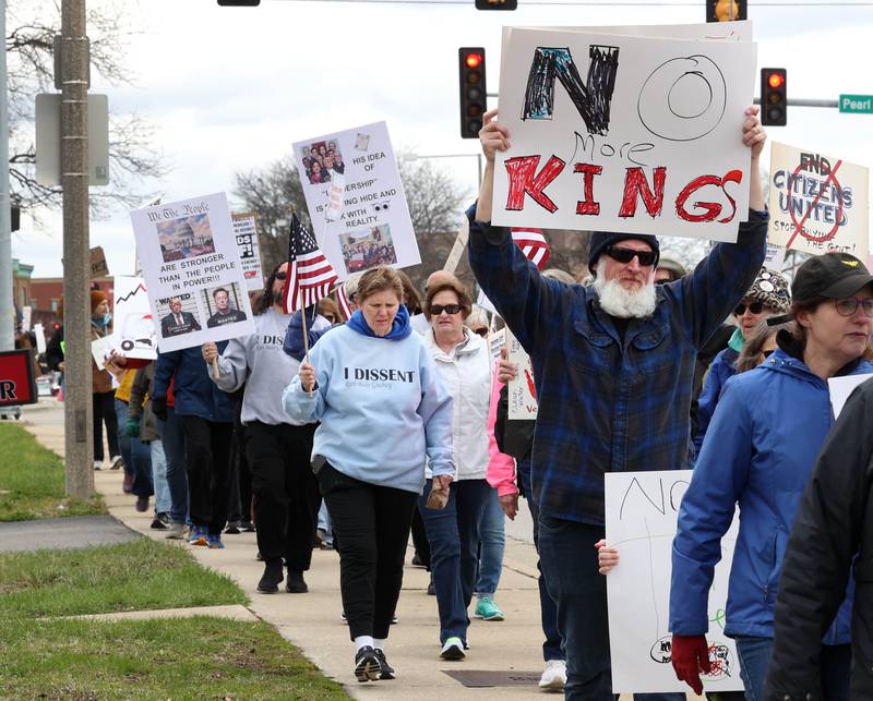 Protesters march down Lincoln Highway Saturday, April 5, 2025, during a Hands Off! rally in DeKalb. Hundreds of people gathered to protest against various policies of President Donald Trump and his administration.
