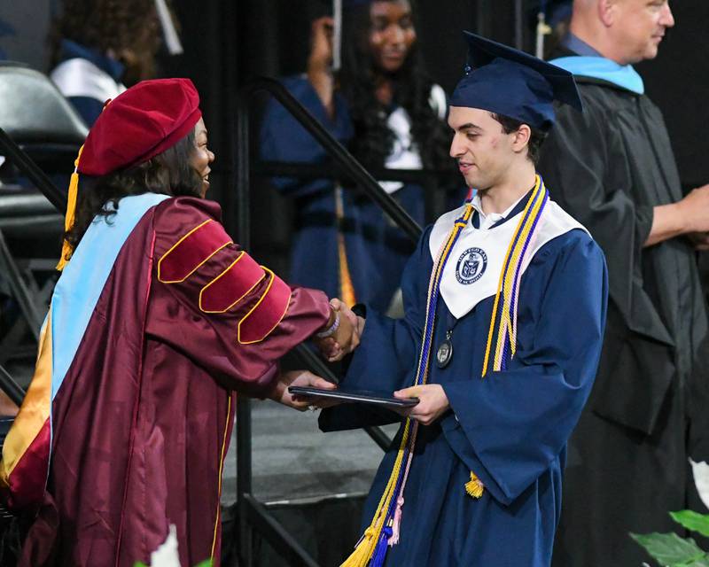 Oswego East senior Samuel Greene receives his diploma on Saturday May 17, 2025, during the graduation ceremony held at the Convocation Center in DeKalb.
