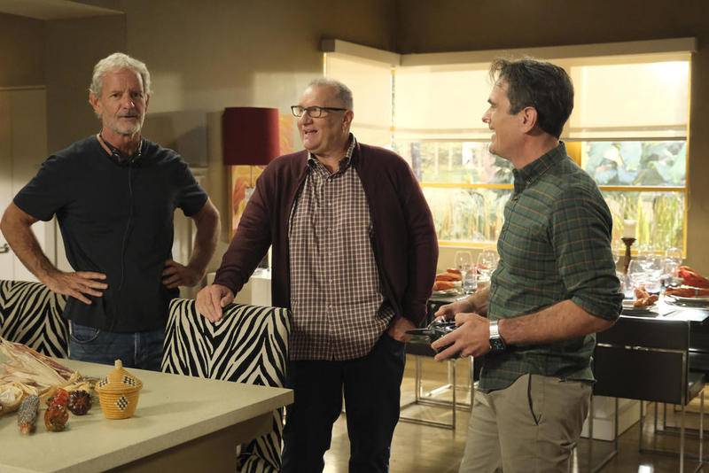 This image released by ABC shows, from left, executive producer Christopher Lloyd, and actors Ed O'Neill and Ty Burrell on the set of "Modern Family."