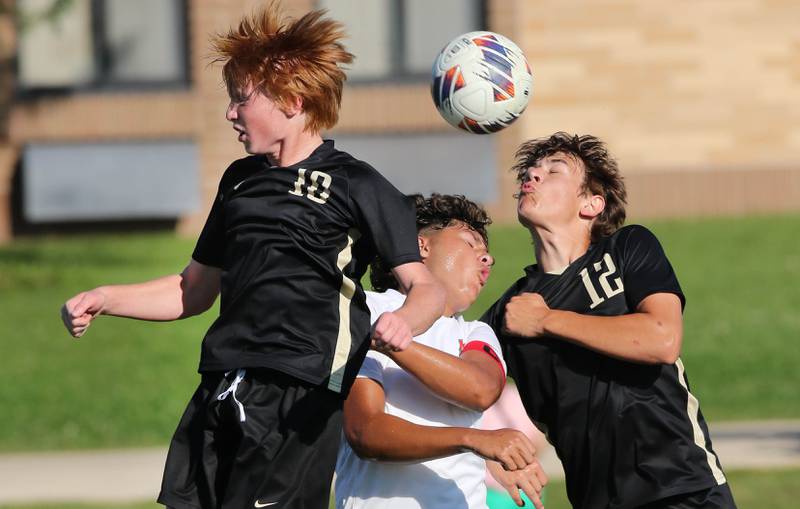 Sycamore's Jameson Carl (left) and Sycamore's Carter England surround La Salle-Peru's Giovanni Garcia as they go for a header during their game Wednesday, Sept. 7, 2022, at Sycamore High School.