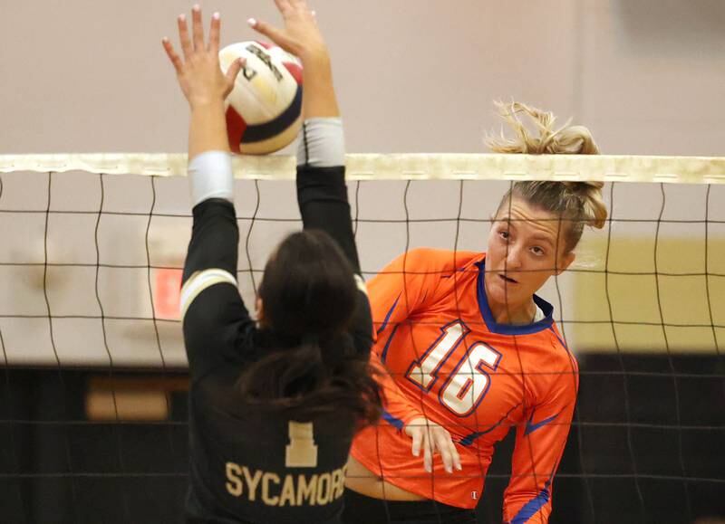 Genoa-Kingston's Alayna Pierce tries to spike the ball through Sycamore's Grace Lichardt during their match Monday, Aug. 28, 2023, at Sycamore High School.