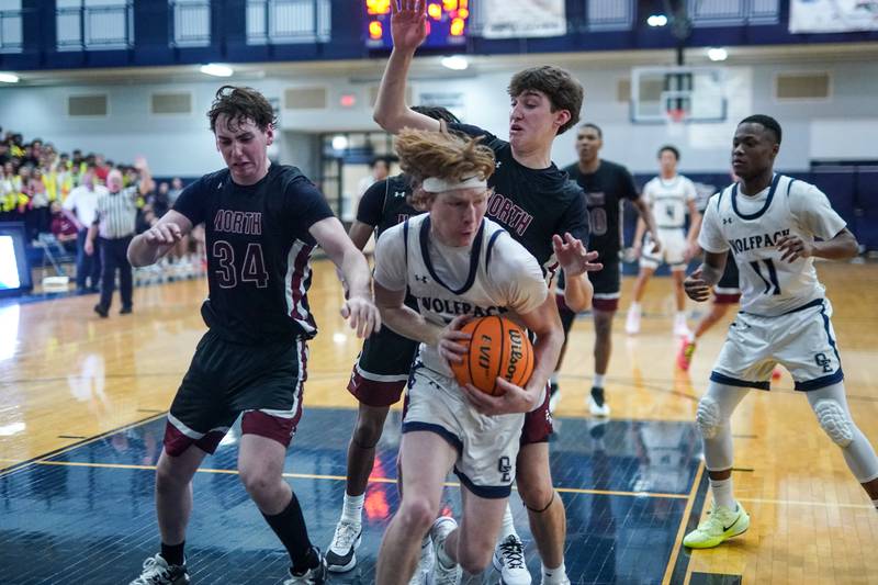 Oswego East's Andrew Pohlman (21) rebounds the ball with seconds left in the 4th quarter of play against Plainfield North during a basketball game at Oswego East High School on Friday, Dec. 6, 2024.