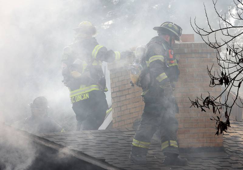 Firefighters begin to climb on the roof of a garage fire in the 1900 block of Shooting Park Road on Monday, Feb. 9, 2026 in Peru. La Salle, Peru, Utica, Oglesby and Spring Valley fire departments were dispatched around 12:15p.m. to the fire.