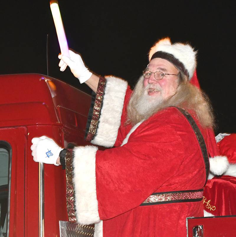 Santa Claus waves to the crowd as he arrives at Forreston's Christmas in the Country on a firetruck on Friday, Dec. 5, 2025.