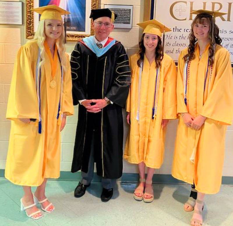 Marquette Academy seniors (from left to right) Lauren Machetta, Illinois Valley Community College President Jerry Corcoran, Mikenna Stacy and Ella Biggins stand in the high school lobby following Marquette's graduation.