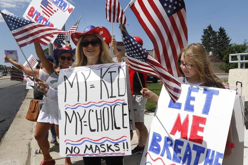 Maria Leibrandt and daughter Gina, 10, of Union, stand with their signs during an Unmask Our Kids rally at the intersection of Rt. 14 and South Main St. on Saturday, Aug. 14, 2021 in Crystal Lake.