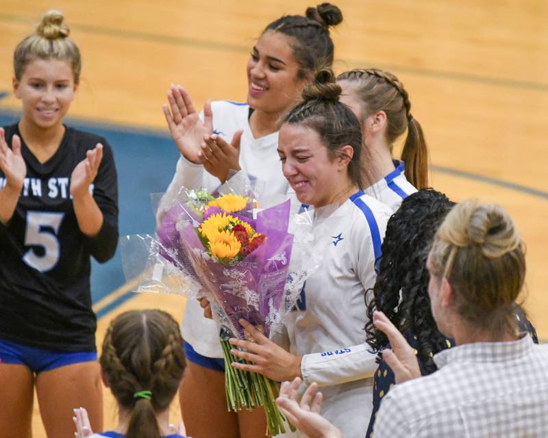 St. Charles North's Haley Burgdorf (23) gets emotional after receiving flowers by her coach when she made her 1,000 careers kill during the game on Wednesday Oct. 2, 2024, while traveling to take on St. Francis High School in Wheaton.