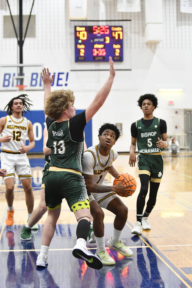 Joliet Catholic Academy's Jayden Armstrong looks to shoot under pressure from Bishop McNamara's Trey Provost during the Fightin' Irish's 79-67 victory over the Hilltoppers in the IHSA Class 2A Peotone Sectional semifinal on March 4, 2025.