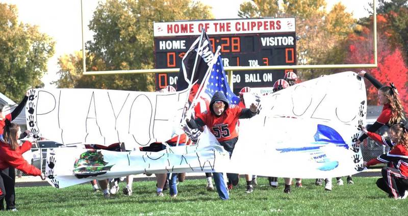 Amboy sophomore Collin O'Malley leads the Clippers football team on to the field for Saturday's playoffs game wearing his No. 55 jersey in honor of his grandfather, Dennis McCoy. The Clippers honored McCoy, who was a member of their 1979 state runner-up team. He was killed in an accident on Oct. 21.