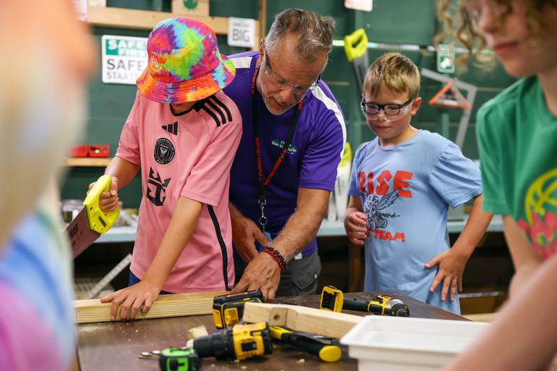 Tim Zydek, center, known by his camp name "Z," helps youth campers with their picnic table project during Tool Time at Camp Shaw-Waw-Nas-See on Wednesday, July 16, 2025.