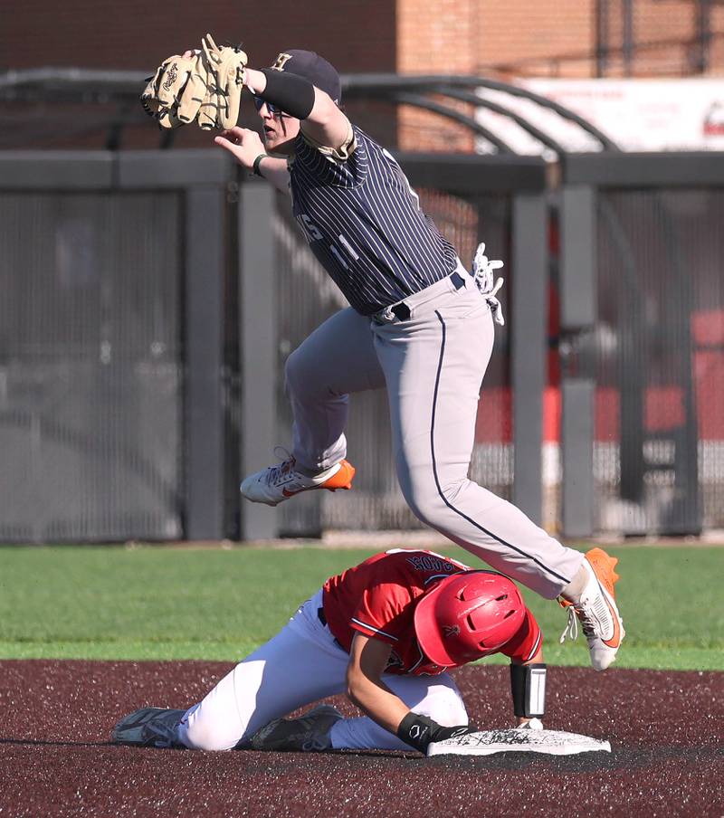 Hiawatha's Kamden Rasmus has to jump over South Beloit's Gabe Najera after tagging him out at second base Thursday, April 16, 2026, during their game at Northern Illinois University in DeKalb.