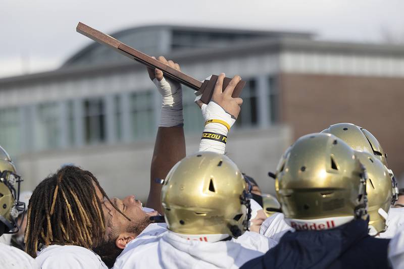 Althoff Catholic’s Jason Dowell raises the trophy after their  52-14 win over Lena-Winslow Friday, Nov. 29, 2024, in the class 1A football state final.