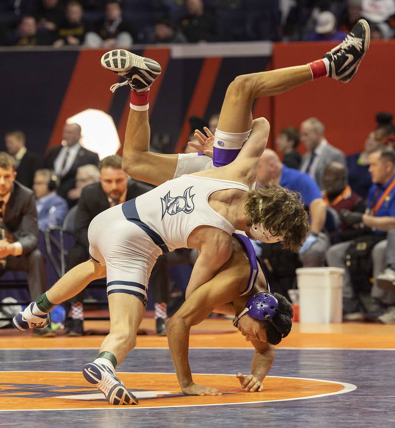 IC Catholic’s Max Cumbee flips Rochelle’s Xavier Villalobos in the 126 pound weight class of the 2A state individual wrestling finals Saturday, Feb. 22, 2025, at State Farm Center in Champaign.