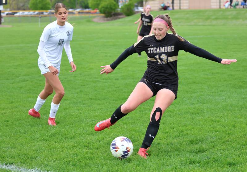 Sycamore's Kylie Runkle kicks the ball ahead of Kaneland's Sophia Rosati during their game Wednesday, April 29, 2026, at Sycamore High School.