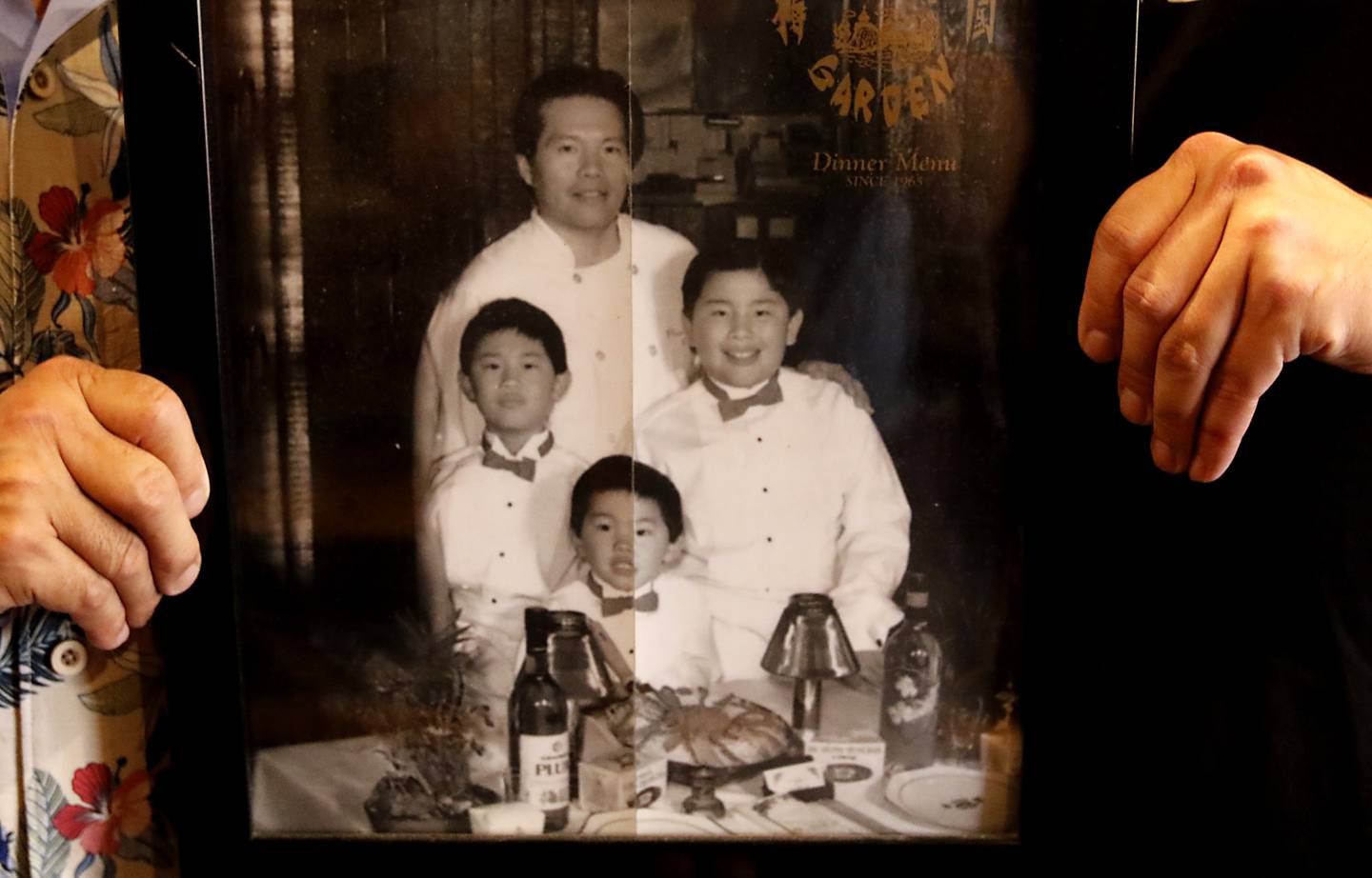 Perry Moy and his son, Jason, hold framed menu features Perry, and Jason and his brothers on the cover  inside the Plum Garden restaurant on Wednesday, July 2, 2025, in McHenry. The oldest single-family run restaurant in McHenry is celebrating its 60th anniversary.