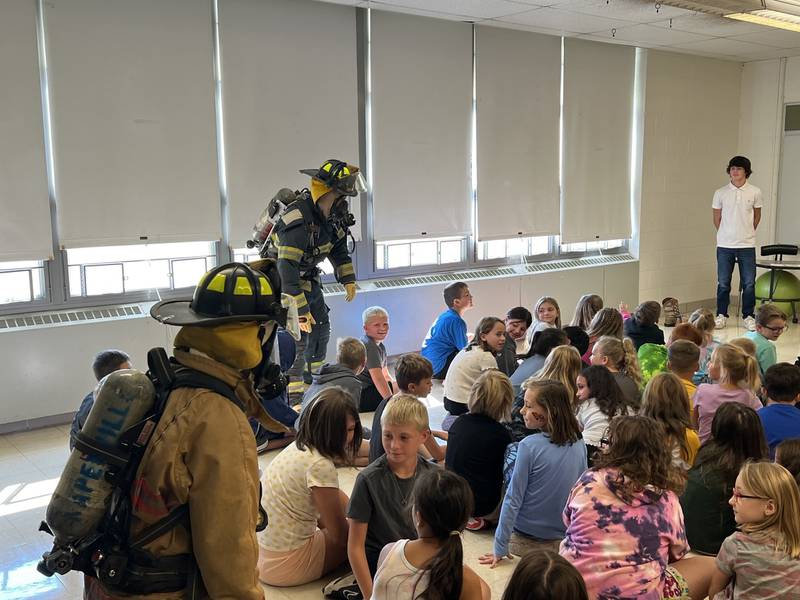Caleb Phillips, Lucas Pfizenmaier and Brandon Anderson show the fire equipment off to a class of Coal City Elementary students.