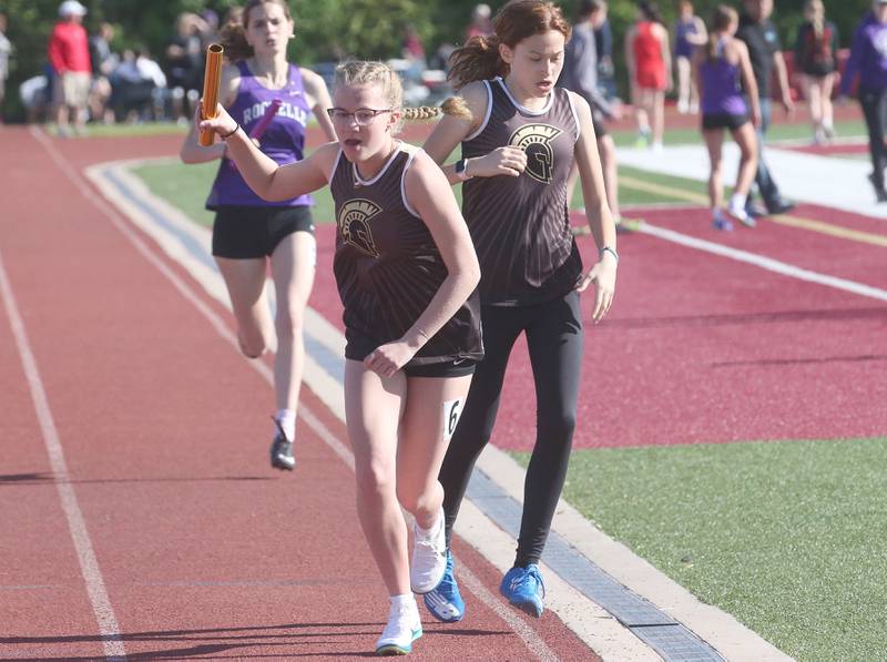 Sycamore's Emalyn Myles runs with the baton after being handed off by teammate Ashley Ortiz in the 4x800 relay during the Interstate 8 Conference girls track championship on Friday, May 9, 2025 at Morris High School.