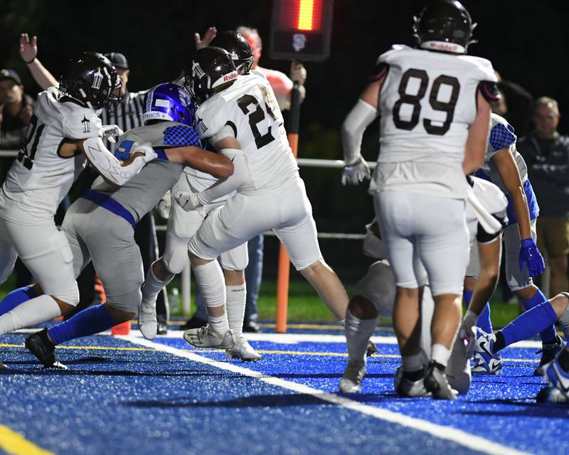 Joliet Catholic Academy Lawrence Stringham, center, crosses the endzone for a touchdown in the first quarter in a short and goal play on Friday Sep. 22, 2023, while St. Francis tries to block the touchdown where it was held at St. Francis in Wheaton.