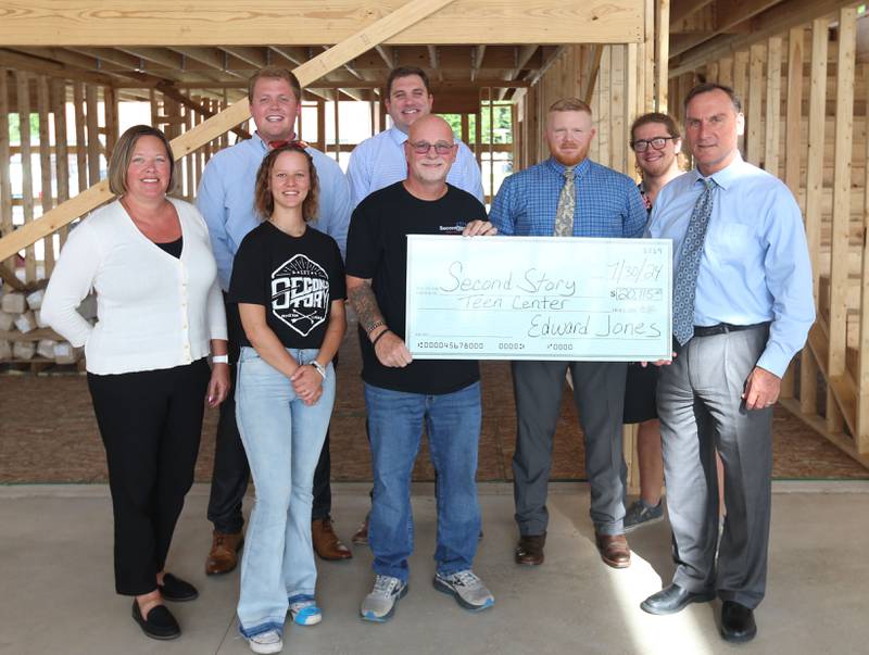 Edward Jones of Princeton made a $20,115 donation to the Second Story Teen Center on Tuesday, July 30, 2024 at the new building in Princeton. Gathered at the check presentation were (from left) Tracy Robbins-EJ-FA; Asriella Jameson-volunteer; Jeff Vanautreve,-co-owner; Paul Brandenburg, -EJ-FA; Chris Kieffer, EJ-FA;. Back row: Tucker Nichols, EJ-FA;, Ryan Blume, .EJ-FA and Dominic Schillaci volunteer. Second Story Teen Center is a nonprofit 501(c)3 free organization servicing Bureau County as a teen drop in center for two nights per week for youngsters grades 6-12. The center is open Tuesday's from 4p.m.-8p.m. and Friday's  6:30p.m.-11:00 p.m. On average 170 youths per week or just over 8000 youths were served in 2023. Each youth is served free meals and have the opportunity to visit with their friends and enjoy many various games. Through out the year motivational speakers will visit that helps students learn. A food and clothing pantry are  available to all youths. Two post secondary scholarship funds are available to teens seeking post-secondary education at colleges or trade schooling. Construction has begun on a new  6,000 square foot building, located at 125 N. Main St. will increase the capacity for providing numerous educational, mentorship, health, nutritional and social programs for Bureau County youth in sixth through 12th grades. Second Story is funded solely on private donations and the building committee is seeking financial and in-kind donations to invest in the future of the youth of Bureau County and their communities.