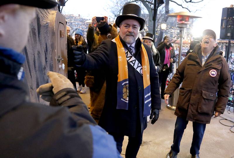 WGN-TV chief meteorologist Tom Skilling laughs as Woodstock Mayor Mike Turner knocks to wake up Woodstock Willie so he can look for his shadow Friday, Feb. 2, 2024, during the annual Groundhog Day Prognostication on the Woodstock Square.