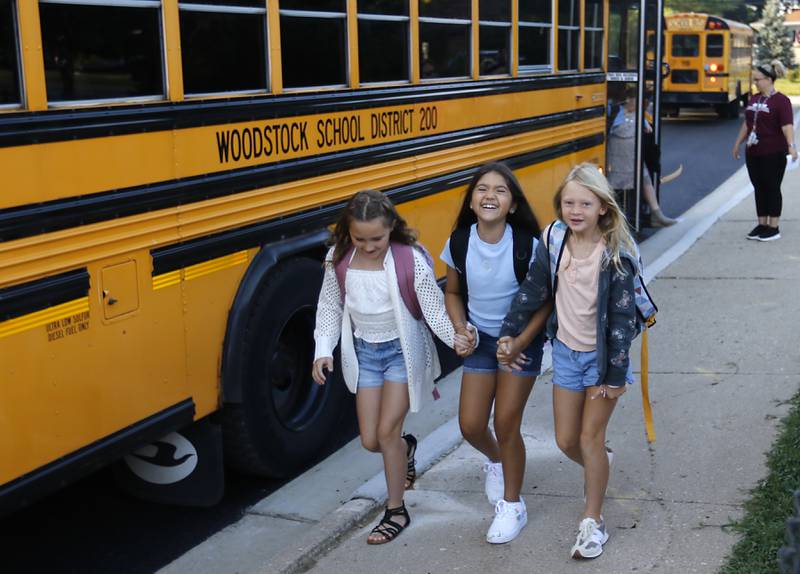 Olson Elementary School students walks to the playground after getting off a buss for the first day of school at the school in Woodstock on Wednesday, Aug. 14, 2024.