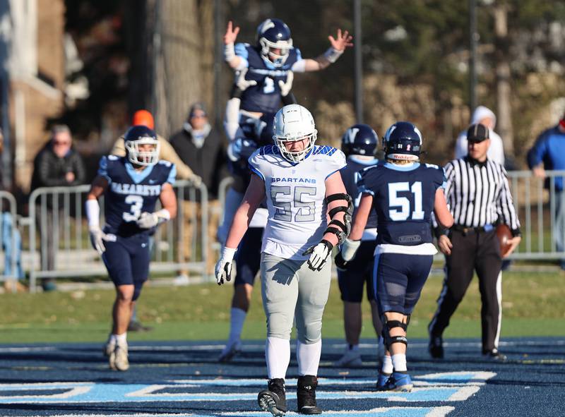St. Francis' (55) Dan Theiss walks off the field as Nazareth celebrates a touchdown during the boys varsity IHSA 5A semifinal between Nazareth Academy and St. Francis high school in La Grange Park, IL on Saturday, Nov. 18, 2023.