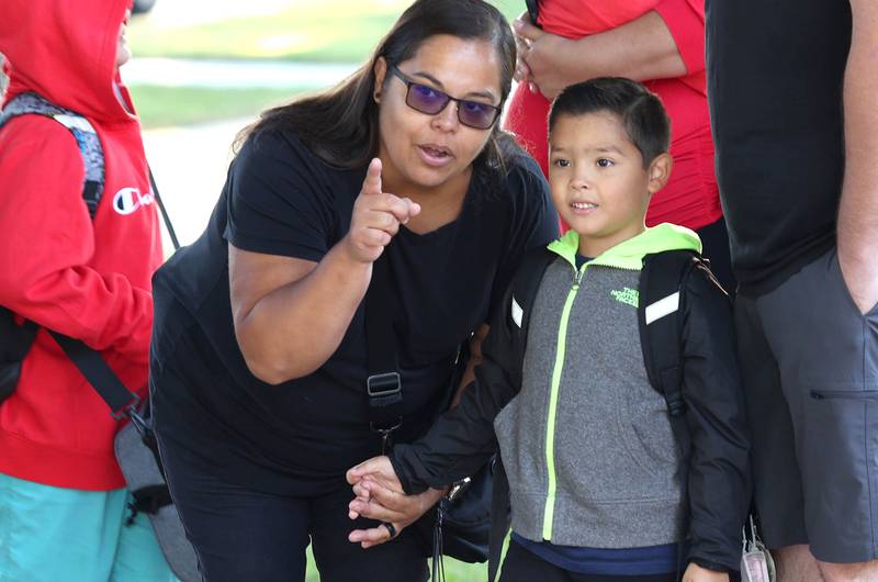 Jasmine Kroyman points out some things to her son Jace as he waits for his bus to Kingston Elementary School for his first day of first grade Tuesday, Aug. 16, 2022, in front of Genoa Elementary School.