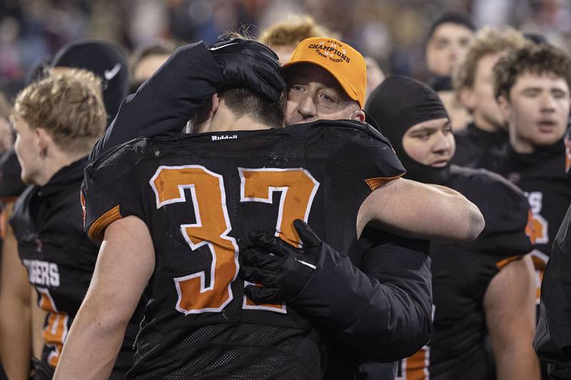 Byron head coach Jeff Boyer hugs Byron’s Caden Considine after the Tigers beat Tolono-Unity 56-50 Friday, Nov. 28, 2025, in the Class 3A football finals at Hancock Stadium at ISU.