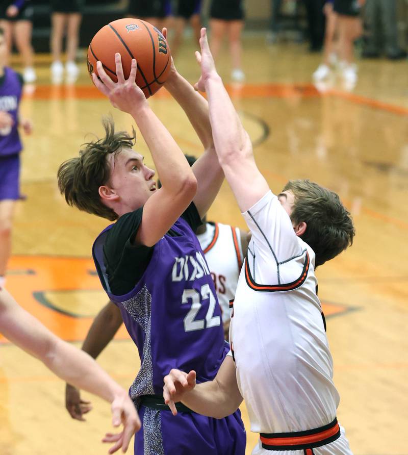 Dixon’s Bryce Feit tries to shoot over DeKalb’s Brayson Barnhardt during their game Tuesday, Dec. 12, 2023, at DeKalb High School.