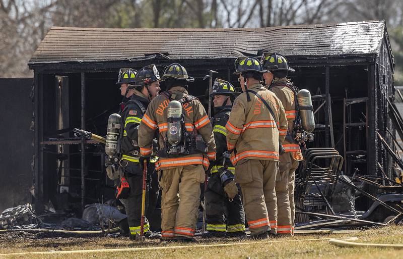 Dixon City and Rural firefighters speak after dousing the flames on a shed Friday, March 14, 2025.
