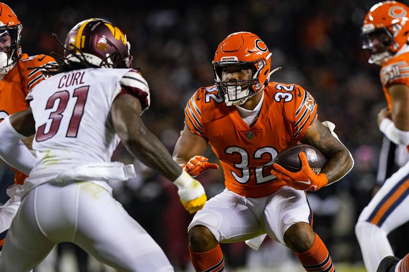 Chicago Bears running back David Montgomery cuts away from Washington Commanders safety Kam Curl in the first half, Thursday, Oct. 13, 2022, in Chicago.