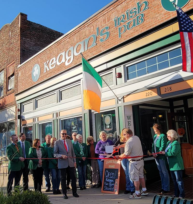 Jim Fritz, owner of Keegan's Irish Pub, cuts the ribbon at the Ottawa city's ceremony at his business at 218 W. Main St. on Friday afternoon.