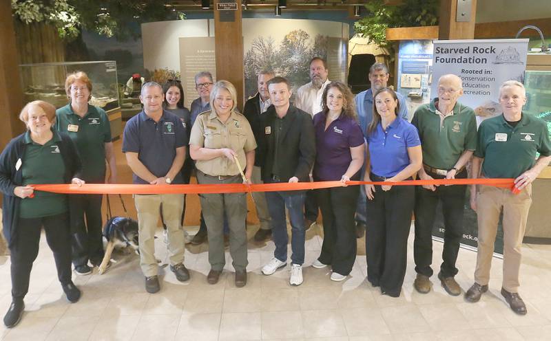 Representatives from Ameren Transmission, Illinois Department of Natural Resources, Ottawa Chamber of Commerce, and the Starved Rock Foundation Board of Directors gathered for a ribbon-cutting ceremony on Thursday, May 8, 2025 at the Starved Rock Visitors Center. The Starved Rock Foundation announced the completion of significant upgrades to the Starved Rock State Park Visitor  Center, just in time for the park’s busy season. The $40,000 project includes all-new lighting installations and refreshed museum exhibits, enhancements designed to create a brighter, more welcoming space that deepens the educational and immersive experience for all who visit. In addition to the lighting improvements, several key museum panels were redesigned and replaced, offering visitors a clearerand more engaging view of the region’s past. The updated exhibits include the Transformations Wall, Early Inhabitants, Park Development and Industry, and two new panels focused on the French Settlement and Fort St. Louis. These refreshed displays provide a deeper and more dynamic understanding of the area’s heritage, from its Indigenous roots to European settlement and beyond.