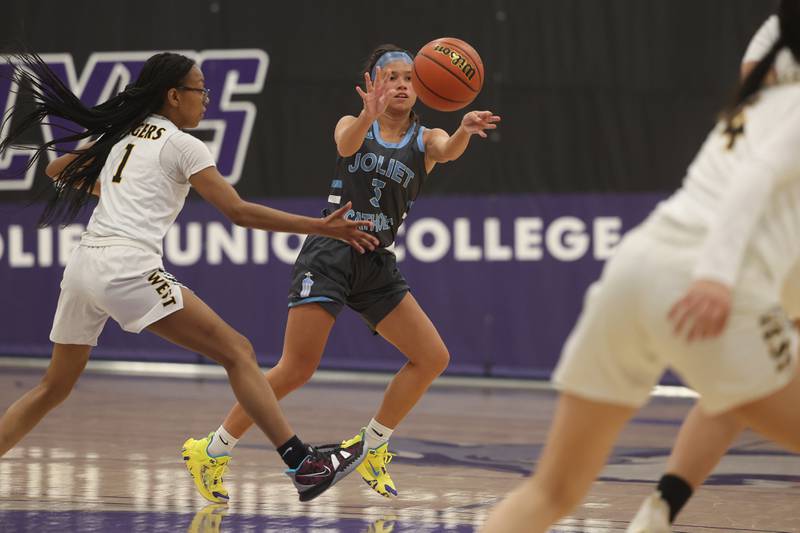 Joliet Catholic’s Elena Czerkies passes the ball against Joliet West in the WJOL Basketball Tournament at Joliet Junior College Event Center on Monday