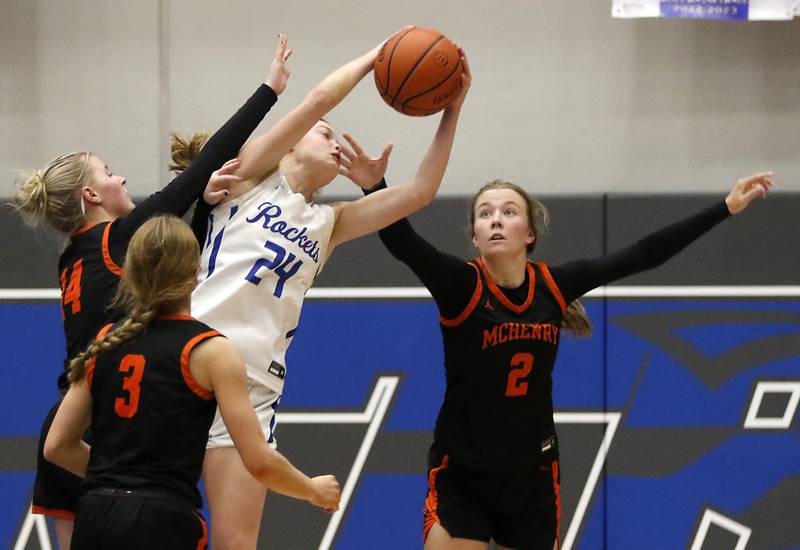 Burlington Central's Page Erickson grabs a rebound surrounded by McHenry's Reese Kominoski, Peyton Stinger, and Emerson Gasmann during a Fox Valley Conference girls basketball game Wednesday, Jan. 4, 2023, at Central High School in Burlington.