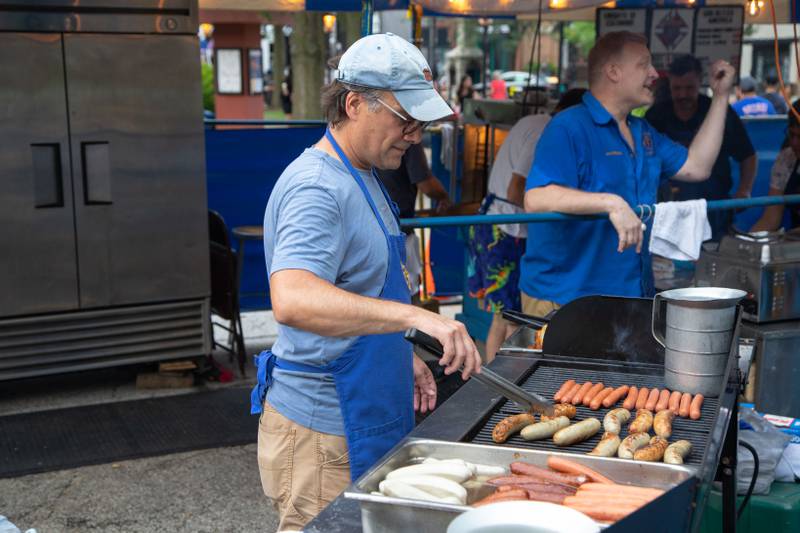 Tony Feldhaus of Geneva grills bratwursts and hotdogs in the Knights of Columbus tent at Swedish Days on Saturday, June 25, 2022.