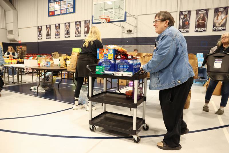 Local residents in need gather supplies at Grace Christian Academy on Thursday, March 12, 2026, following the EF-3 tornado that tore through Kankakee County on March 10. The school, which is on the outskirts of Aroma Township along Waldron Road, canceled classes in order to become a supply and meal hub for those impacted by the storm.