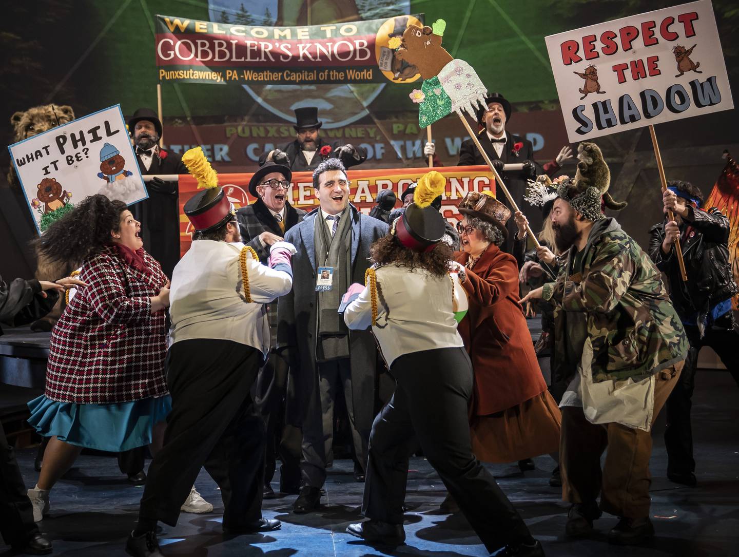 Groundhog Day: The Musical, based on the classic Bill Murray film comedy, is the story of Phil Connors (Alex Syiek, center), a cynical TV weatherman stuck in a never-ending nightmare in a small town whose claim to fame is meteorologist groundhog Punxsutawney Phil. Paramount Theatre’s Midwest regional premiere of Groundhog Day: The Musical runs through March 13, 2022. For tickets and information, visit ParamountAurora.com, or call the Paramount box office, (630) 896-6666. Credit: Liz Lauren
