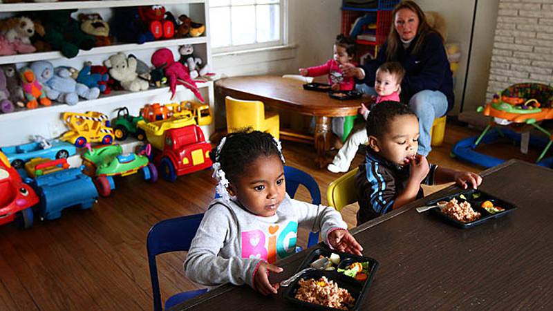 Amirah Newsom (left), 3, and Caden McCoy (front right), 2, start lunch by eating the fruit portion of their meal Dec. 8 at Diana Hodge’s day care center in DeKalb. Hodge’s day care takes part in the Child and Adult Care Food Program.